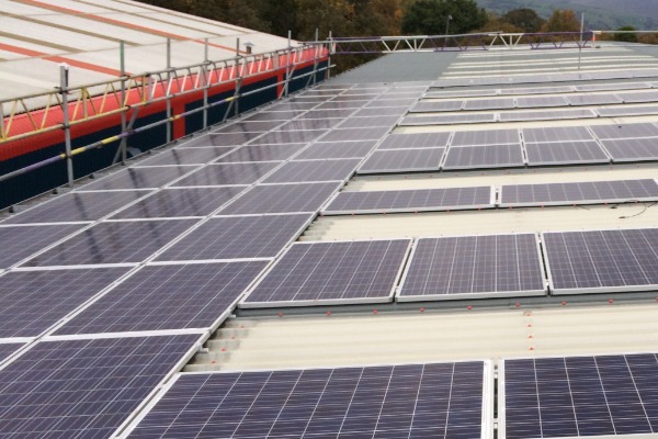 Commercial PV system under construction on roof of business in Manchester, UK